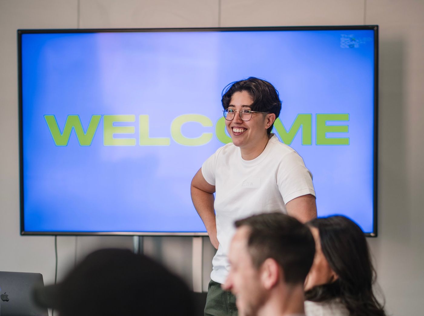 Ella laughing in front of a Welcome screen at an event